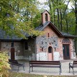Kaplica św. Stanisława Biskupa w Krzeszowicach. Niski kamienno-ceglany budynek znajdujący się w parku.