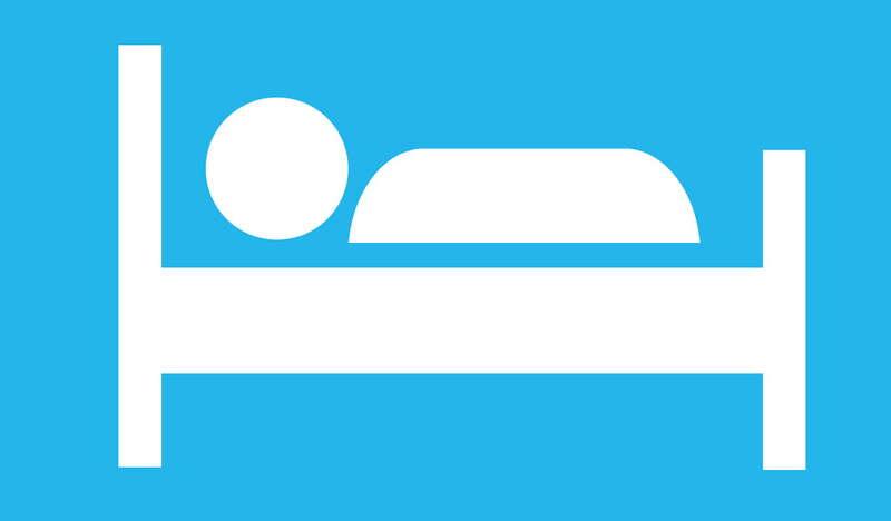 Grafika oznaczająca obiekt noclegowy, przedstawia schematycznie pokazana postać leżąca w łóżku.