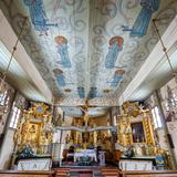 Wnętrze kościoła. Biało-złote ołtarze, jasne ściany z wymalowanymi scenami Drogi Krzyżowej. Przedstawienia świętych na suficie.