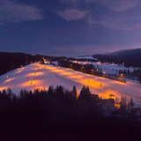 Widok na oświetloną stację narciarską Wierchomla w zimowy wieczór