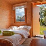 Pokój z podwójnym łóżkiem, drewniane ściany, wyjście na ogród